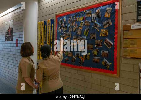 CHICAGO (20. Januar 2023) Ein Kadett Des George Westinghouse College Prep High School Navy Junior Reserve Officers Training Corps (NJROTC) (rechts) zeigt Fotos der Einheit an Rear ADM. Jennifer Couture, Commander, Naval Service Training Command (NSTC) (links), während eines Besuchs vor Ort in NJROTC am 20. Januar. Couture und ihr NSTC-Personal mit Hauptsitz in Naval Station Great Lakes, Illinois, beaufsichtigen das NJROTC-Programm, das aus mehr als 600 Einheiten in den USA besteht. Stockfoto