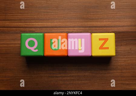 Bunte Würfel mit Wort Quiz auf Holztisch, flach liegend Stockfoto