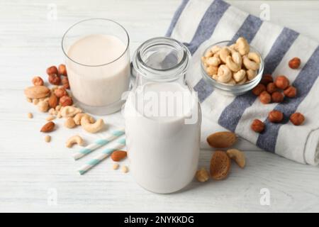 Verschiedene Nussmilch auf weißem Holztisch Stockfoto