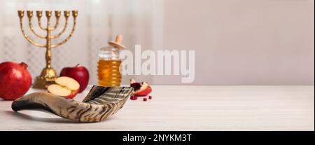 Shofar und andere Festtagscharakteristika von Rosh Hashanah auf weißem Holztisch im Innenbereich, Platz für Text. Bannerdesign Stockfoto