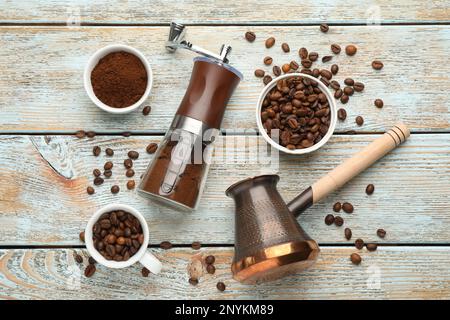 Manuelle Kaffeemühle, Jezve, Pulver und Bohnen auf Holztisch, flach liegend Stockfoto