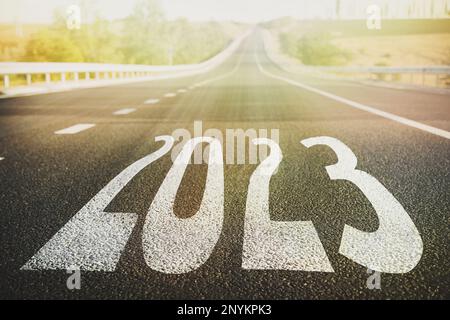 Beginnen Sie das neue Jahr mit neuen Visionen und Ideen. 2023 Nummern auf Asphaltstraße Stockfoto