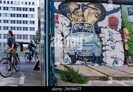 East Side Gallery. Brezner und Honecker küssen sich auf Trabi über die Mauer. Berlin. Deutschland Stockfoto