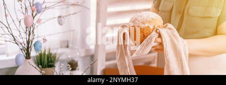 Frohe osterferien im Frühling. Eine junge Hausfrau hält einen frisch gebackenen Kuchen oder traditionelles Brot in den Händen. Traditioneller han Stockfoto
