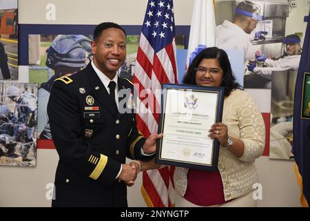 Brigg. Gen. Daryl O. Hood (links), kommandierender General des 20. Kommandos für chemische, biologische, radiologische, nukleare und explosive Stoffe (CBRNE), Überreicht Linda Amarsingh (rechts) bei der Ruhestandszeremonie ihres Mannes, Major William J. Cook, am 21. Februar in Aberdeen Proving Ground, Maryland, ein Dankesschreiben. Amarsingh ging auch aus der US-Armee in den Ruhestand. USA Armeefoto von Angel D. Martinez-Navedo. Stockfoto