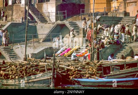 Indien, Varanasi. Die Toten warten am Ganges Fluss auf die Einäscherung vor dem Wald. Stockfoto