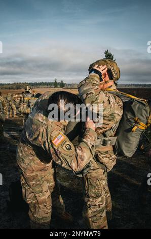 EIN US-AMERIKANISCHER Heer-Sprungmeister mit 1. Special Forces Group (Airborne), links, inspiziert Fallschirmspringer, bevor er über die Joint Base Lewis-McChord springt, Washington, 20. Januar 2023. Spezialeinsatzkräfte führen routinemäßig statische Streckensprünge durch, um die Bereitschaft und Leistungsfähigkeit der Luft aufrechtzuerhalten. Stockfoto