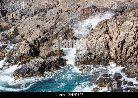 Surfen Sie in Felsen in der Nähe des Hafens von El Cotillo, Fuerteventura. Stockfoto