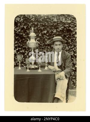 Original-viktorianisches Foto eines Gentlemen, der eine Jacke, eine Krawatte und einen Bootsfahrer trägt. Auf einem Tisch befindet sich eine große Worcester Challenge Vase,/Regatta-Trophäe zum Rudern und andere Pokale, möglicherweise Mitglied einer gefrästen vier-Mannschaft. Worcester Gegend, Großbritannien, ca. 1897-1899 Stockfoto