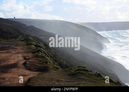 Sprühnebel steigt über die Klippen zwischen St. Agnes und Chapel Porth an der Küste von Nord-Cornish nahe St. Agnes, Cornwall, Großbritannien – John Gollop Stockfoto