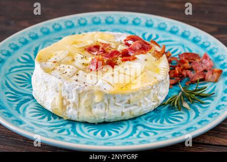 Gebackener Camembert-Käse mit gebratenem Speck Stockfoto