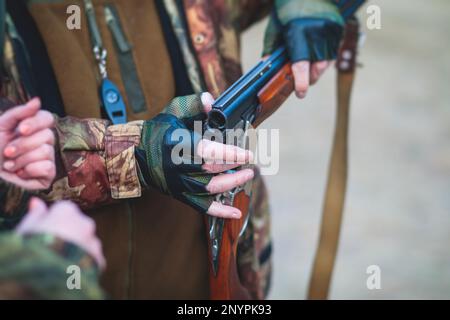 Ein Prozess der Jagd während der Frühjahrsjagd, ein Prozess der Entenjagd, eine Gruppe von Jägern in Tarnkleidung mit Gewehr und Reloadin Stockfoto