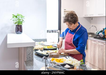 Alte Frau, die in der Küche kocht Stockfoto