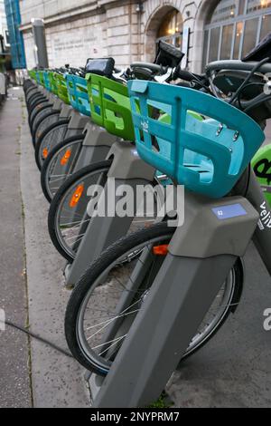 Paris, Frankreich. Februar 19. 2023. Eine Reihe von Elektrofahrrädern zum Selbstbedienungsverleih vor einer RER-Station. velib Fahrradstation. Stockfoto