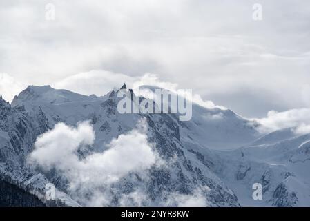 Schichten stürmischer Wolken, die einen einfarbigen Blick über den Mont Blanc und die umliegenden Berge mit der Aiguille du Midi in der Silhouette von Chamonix, Stockfoto