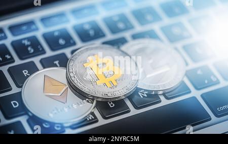 Bitcoin und andere Kryptowährungen werden auf einer Laptop-Tastatur platziert Stockfoto