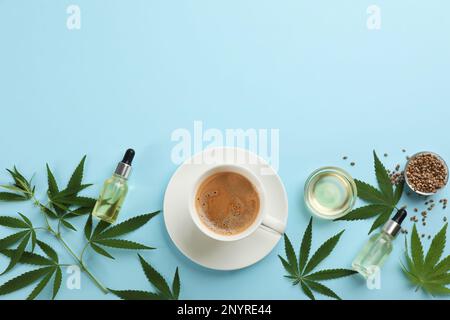 CBD-Öl, THC-Tinktur, Tasse Kaffee und Hanfblätter auf hellblauem Hintergrund, flach gelegt. Platz für Text Stockfoto