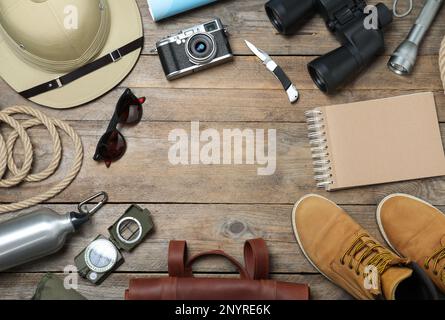 Flache Verlegung mit verschiedenen Safari-Accessoires auf Holzhintergrund, Platz für Text Stockfoto