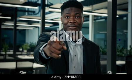 afroamerikanischer junger männlicher Geschäftsmann selbstbewusster Anführer Arbeitgeber Zeige mit dem Finger hey, du Handgeste motivierter lächelnder 30s Mann billigen Geschäftsidee Stockfoto