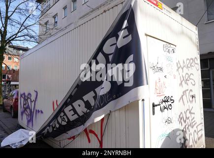 Hamburg, Deutschland. 19. Februar 2023. Ein Poster hat sich aus dem Behälter einer geschlossenen Corona-Teststation gelöst. Kredit: Marcus Brandt/dpa/Alamy Live News Stockfoto