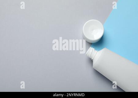 Leere Tube mit Zahnpasta und Deckel auf farbigem Hintergrund, flach liegend. Platz für Text Stockfoto