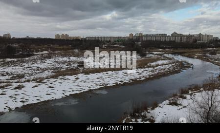 Der gewundene Fluss im Stadtpark. Winterlandschaft. Bewölktes Wetter. Luftaufnahmen. Stockfoto