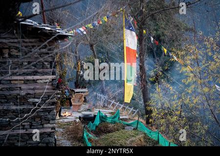 Heilige religiöse bunten Gebete Flaggen alt und zerrissen außerhalb einer hölzernen Hütte in bhuddistischer Gebetsformel üblich in Bergstationen in Stockfoto