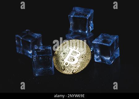 Eis und Bitmünze. Einfrieren von Konten mit Kryptowährung. Gefrorene Bitcoin-Münze. Stockfoto