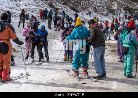 Panning-Aufnahme von Menschen in Winterkleidung, die im Schnee spielen, Ski fahren, rutschen, am Snow Point in Lahul, manali solang ein beliebter Touristenort während Stockfoto