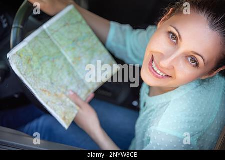 Junge Fahrerin mit einer Karte in der Hand. Stockfoto