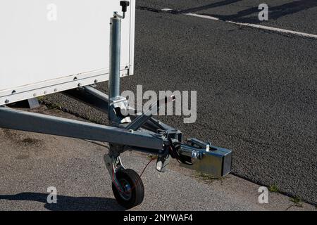 Nahaufnahme der Zugvorrichtung eines auf der Fahrbahn stehenden Pkw-Anhängers. Stockfoto