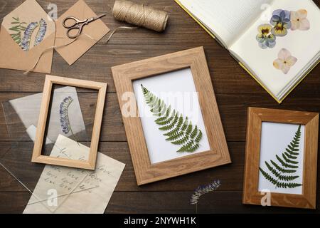 Flache Laienzusammensetzung mit getrockneten Blumen und Pflanzen auf Holztisch Stockfoto