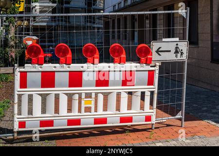 Rote und weiße Barriere aus tragbarem Kunststoff mit roten Signalleuchten, die den Zugang zur Baustelle verbieten. Stockfoto