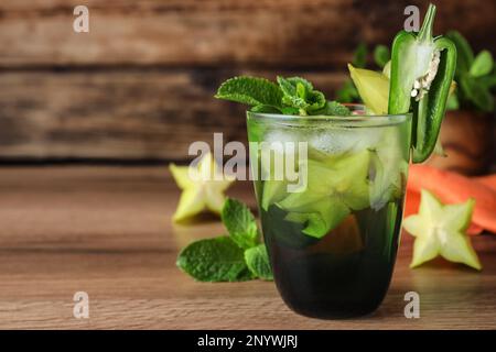 Würziger Cocktail mit Jalapeno, Karambola und Minze auf einem Holztisch. Platz für Text Stockfoto