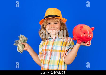 Bargeld-Dollarrechnungen und Sparschwein-Konzept. Ein Junge, der die Sparschwein-usd-Dollar-Banknoten einsteckt Stockfoto