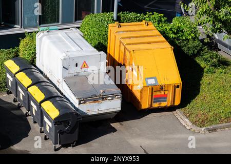 Mülltonnen und große Behälter stehen im Hof des Hauses. Blick von oben. Stockfoto