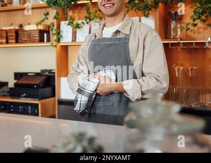 Gekürzt von einem unbekannten Barkeeper in einer Schürze, der sich die Hände mit einem Handtuch abwischte, während er an der Theke stand Stockfoto