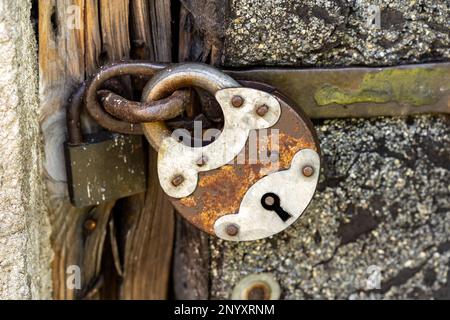 Ein großes altes rostiges Metallschloss, Objektdetails, Nahaufnahme, großes Stahlschloss, Schlüsselloch, verschlossene Tür, Sicherheitssymbol, Schutz abstrakt CO Stockfoto