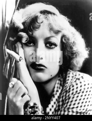 1932 , USA : die Filmschauspielerin JOAN CRAWFORD in RAIN ( Pioggia ) von Lewis Milestone , Aus einer Geschichte von W. Somerset Maugham - FILM - KINO - Porträt - Rituto - gioiello - gioielli - Juwelen - Ring - Anello - Neo - Maulwurf - stella - Star - Bijoux - Armband - Armbänder - DIVINA - VAMP - bionda - blondes Haar - Capelli biondi... - Archivio GBB Stockfoto