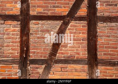 Holzrahmen Wandstruktur mit braunen Balken und roten Ziegelsteinen Stockfoto