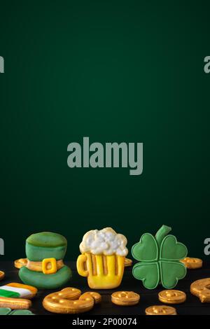 Vertikaler Hintergrund der Saint Patricks mit goldenem Hufeisen und vierblättrigem Klee auf dunklem Hintergrund Stockfoto