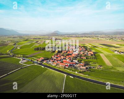 Luftaufnahme eines kleinen, dicht besiedelten Gebiets auf dem Land an einem sonnigen Tag Stockfoto