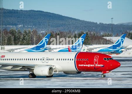 Ein Flugzeug von Norwegian Airlines vor einigen Flugzeugen von Norse Atlantic Airways am Flughafen Oslo. Stockfoto