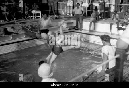 Zwei Menschen kämpfen an einer fettigen Stange an Bord der MV Aureol auf dem Weg von Liverpool nach Tema in Ghana c.1958 Stockfoto