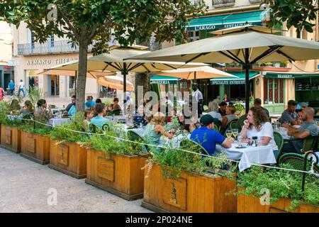 08-31-2022 Perpignan, Frankreich. Die Gäste genießen den Sommer zum Mittagessen in einem Café im Freien in der Innenstadt in einer der Städte an der französischen Riviera: Familien mit Kindern, AFR Stockfoto