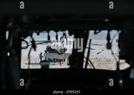 EIN US-AMERIKANISCHER Der dem 1-211. Luftbataillon der Nationalgarde der Utah Army zugeteilte Chef der Army führt die erforderlichen Überprüfungen an einem UH-60 Black Hawk Helikopter durch, bevor er Soldaten der 19. Special Forces Group (Airborne) einlädt, um am 21. Januar 2023 in der Nähe von Camp Williams, Utah, einen Luftsprung durchzuführen. Der Besatzungschef ist für die gesamte Hubschraubercrew verantwortlich und gilt als verantwortlich für alles, was im oder am Hubschrauber passiert. (Utah Army National Guard Foto von SPC. Mackenzie Willden) Stockfoto