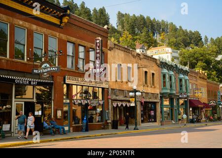 Historische Saloons, Bars und andere Attraktionen bringen Besucher zur historischen Main St. in der Goldrauschstadt Deadwood, South Dakota, in den Black Hills. Stockfoto