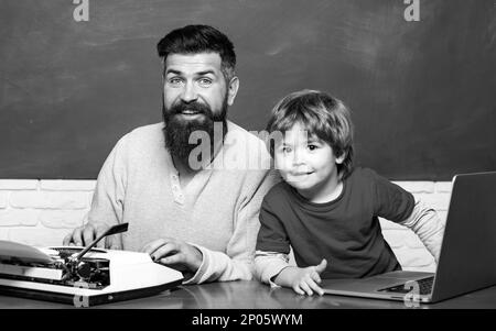 Jung oder erwachsen. Glückliche Familie. Kindererziehung. Vorschulschüler. Männerlehrer spielen mit Vorschulkind. Lehrer und Schuljunge, die im Unterricht ein Notebook benutzen. Stockfoto