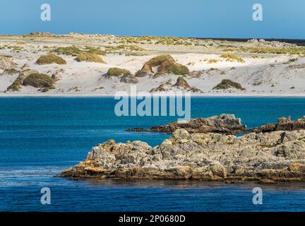 Sandstrände und Felsen bei der Annäherung an den Hafen von Stanley auf den Falklandinseln vom Meer aus Stockfoto