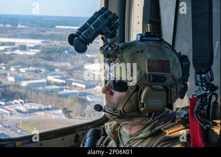 Staff Sgt. Dennis McClain, 146. Air Support Operations Squadron, Oklahoma City Air National Guard, Tactical Control Party Airman, schaut von hinten auf einen HH-60G Pave Hawk Helikopter, der über Savannah, Georgia, fliegt, während der Übung Sunshine Rescue am 23. Januar 2023. In dieser Übung werden Airmen auf führende Such- und Rettungskapazitäten für Kampfhandlungen der nächsten Generation geschult. Während dieser Übung werden die taktische Luftregulierungsorganisation und die Pararescue Airmen fortschrittliche Kommunikations-, Steuer- und Kontrolltechnologien einsetzen, die mit Den Flugzeugen A-10C Thunderbolt II und HH-60G Pave Hawk Helic verbunden sind Stockfoto